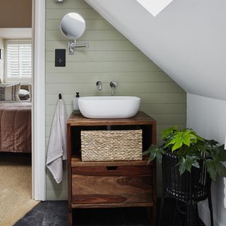 bathroom sink on wooden unit under sloped ceiling