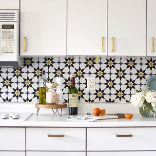 Wallpapered faux tile kitchen backsplash in Moroccan style design in white kitchen