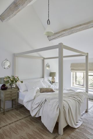 A bedroom with bleached ceiling beams