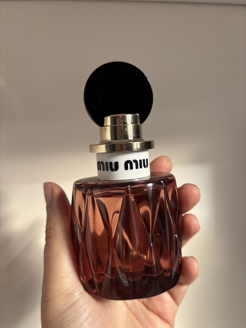 Mica Ricketts holding bottle of Miu Miu Miutine Intense