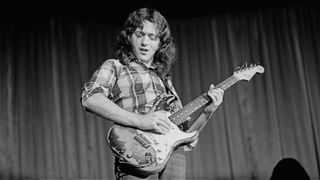 A black and white photo of Rory Gallagher playing his '61 Strat