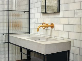 concrete basin and countertop in bathroom with white metro tiles on wall