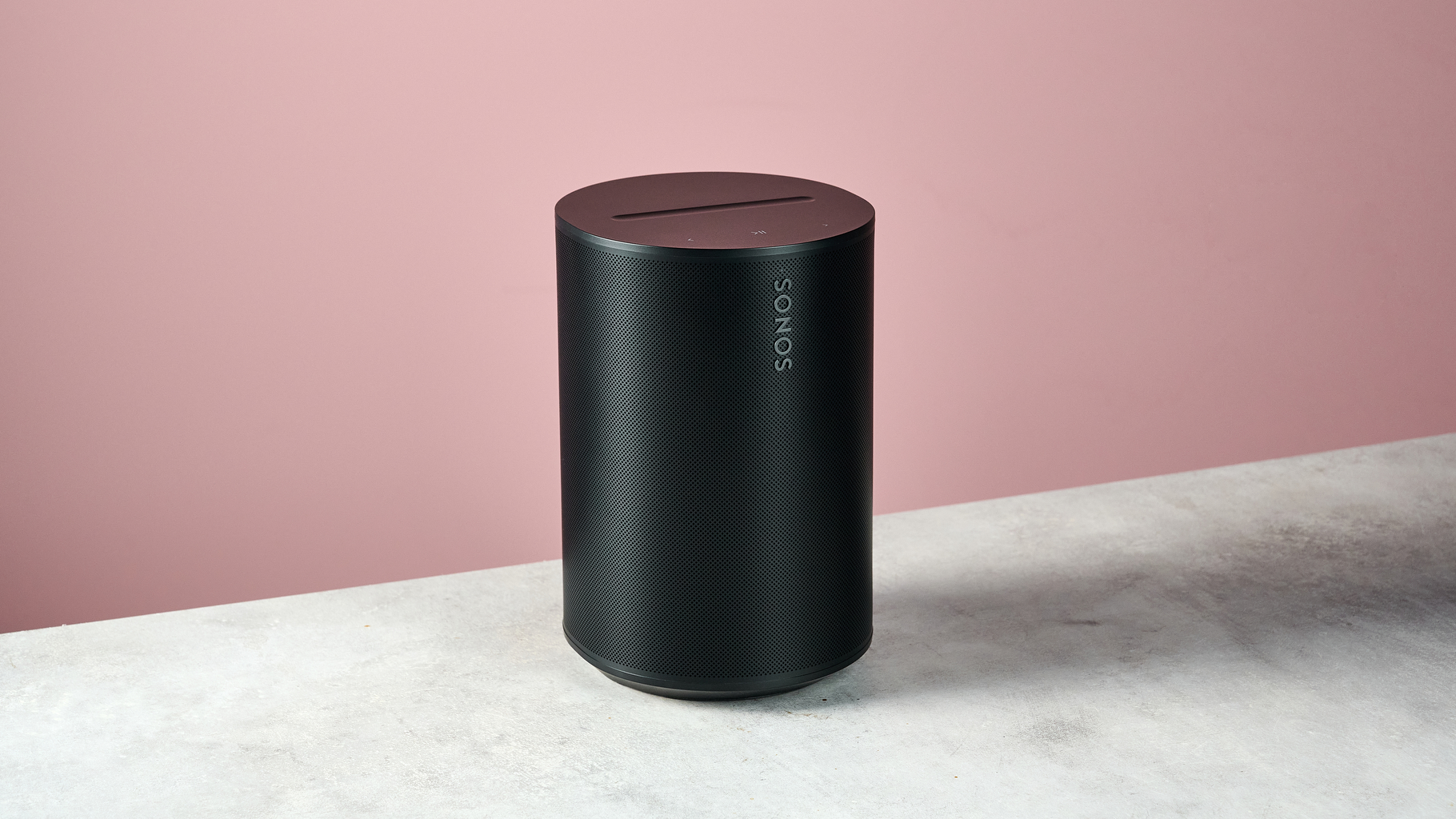 The Sonos Era 100 SL at a 3/4s angle in front of a pink background.