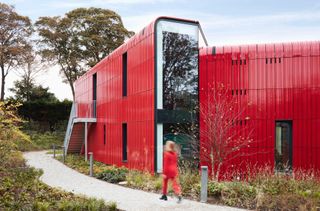 Maggie centre with red cladding on roof reaching ground
