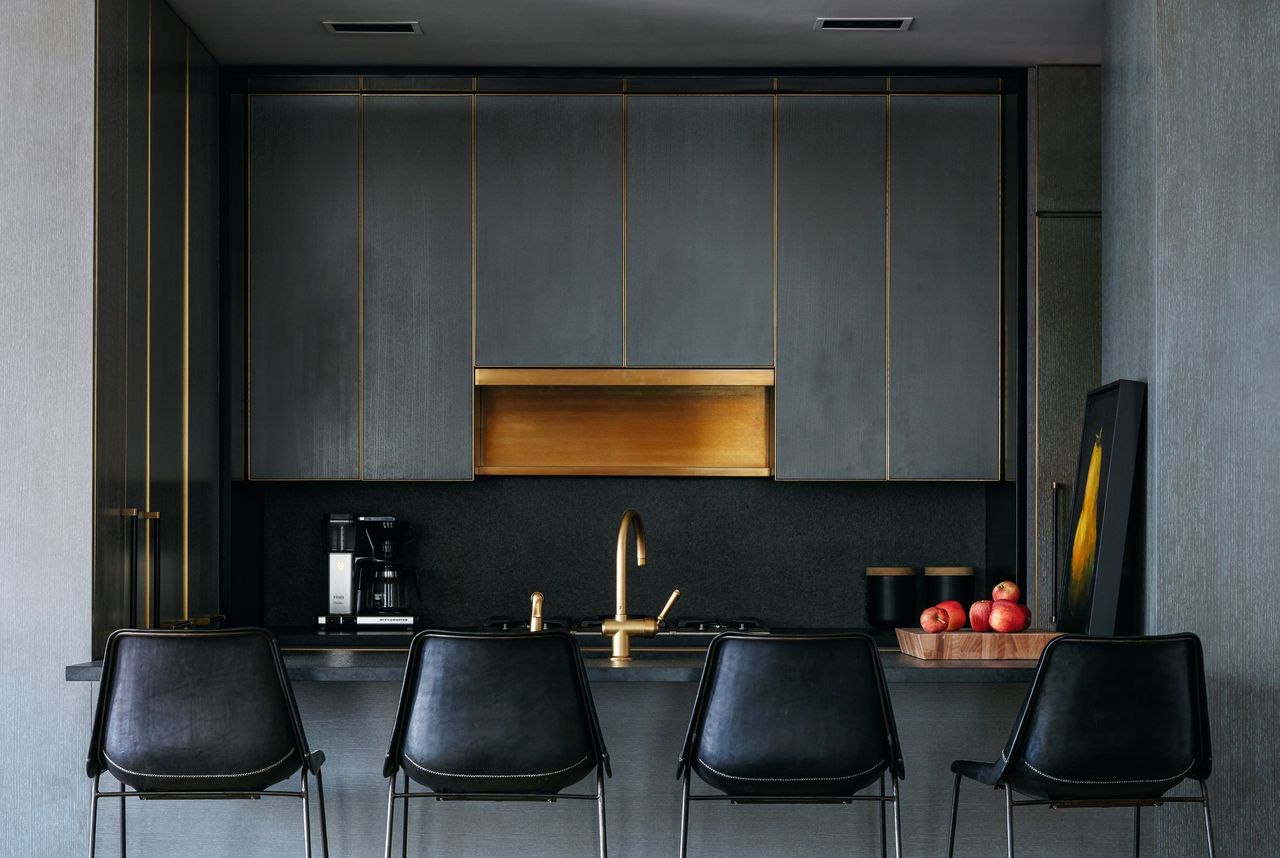 A small kitchen in a dark tone, with gold accents