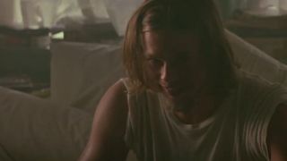 Brad Pitt in a ratty t-shirt on a couch in True Romance