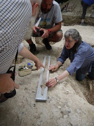 Archaeologists examine an ancient sword found in the grave of the sixth-century Saxon warrior.