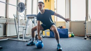 Man lifting kettlebell in gym