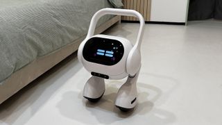 LG:s Self Driving AI Home Hub sitter vid en säng, med "slutna" ögon på skärmen.