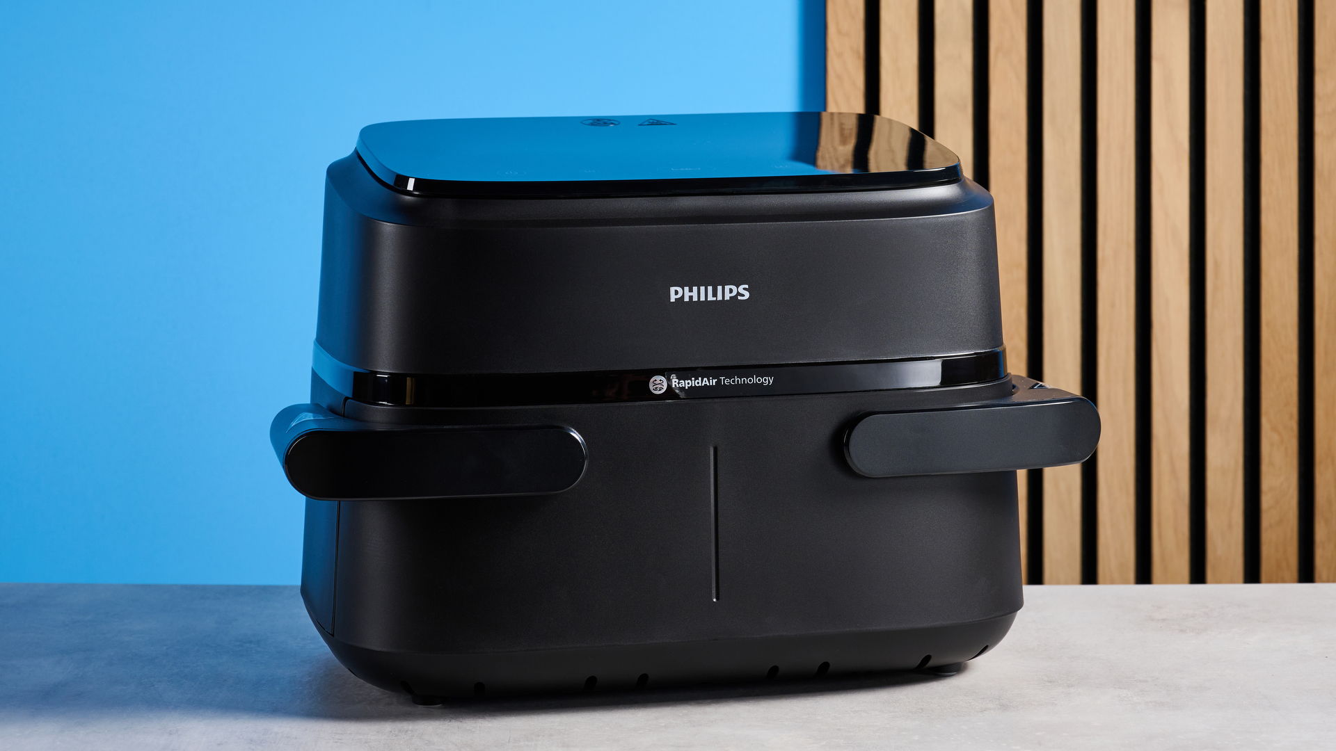The Philips 1000 Series FlexDrawer Air Fryer photographed in front of a blue background. 