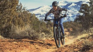 A woman riding down a dusty trail