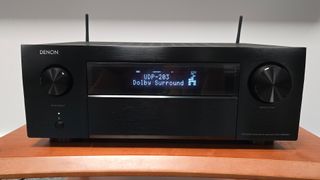 Denon AVC-X6800H from front on wooden rack