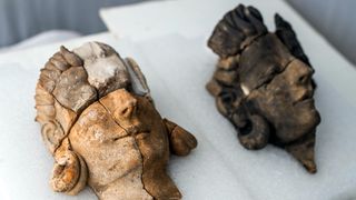 Two carved stone reliefs of human faces. 