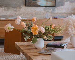 Wood coffee table with sculptural floral arrangement in ikebana style