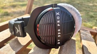 Beyerdynamic DT 990 Pro X wired headphones in black on a chair