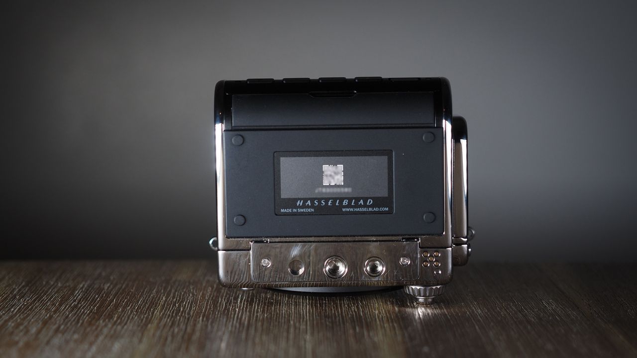 The Hasselblad 907X &amp; CFV 100C medium format camera with digital back, on a wooden table with artistic lighting