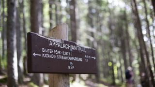 A sign on the Appalachian Trail points hikers to Mt Katahdin in Maine