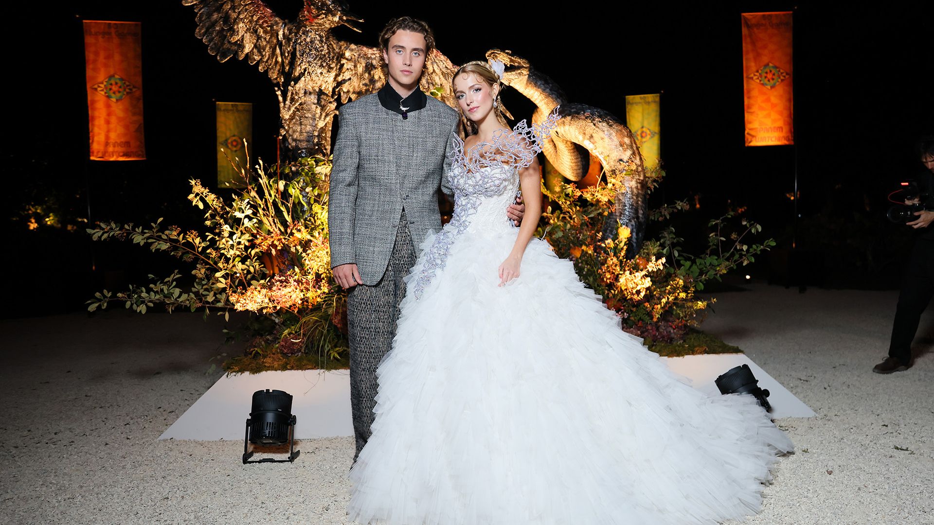 Joseph Zada and McKenna Grace wear a suit and dress perfectly fit for Panem at museum event October 2026.