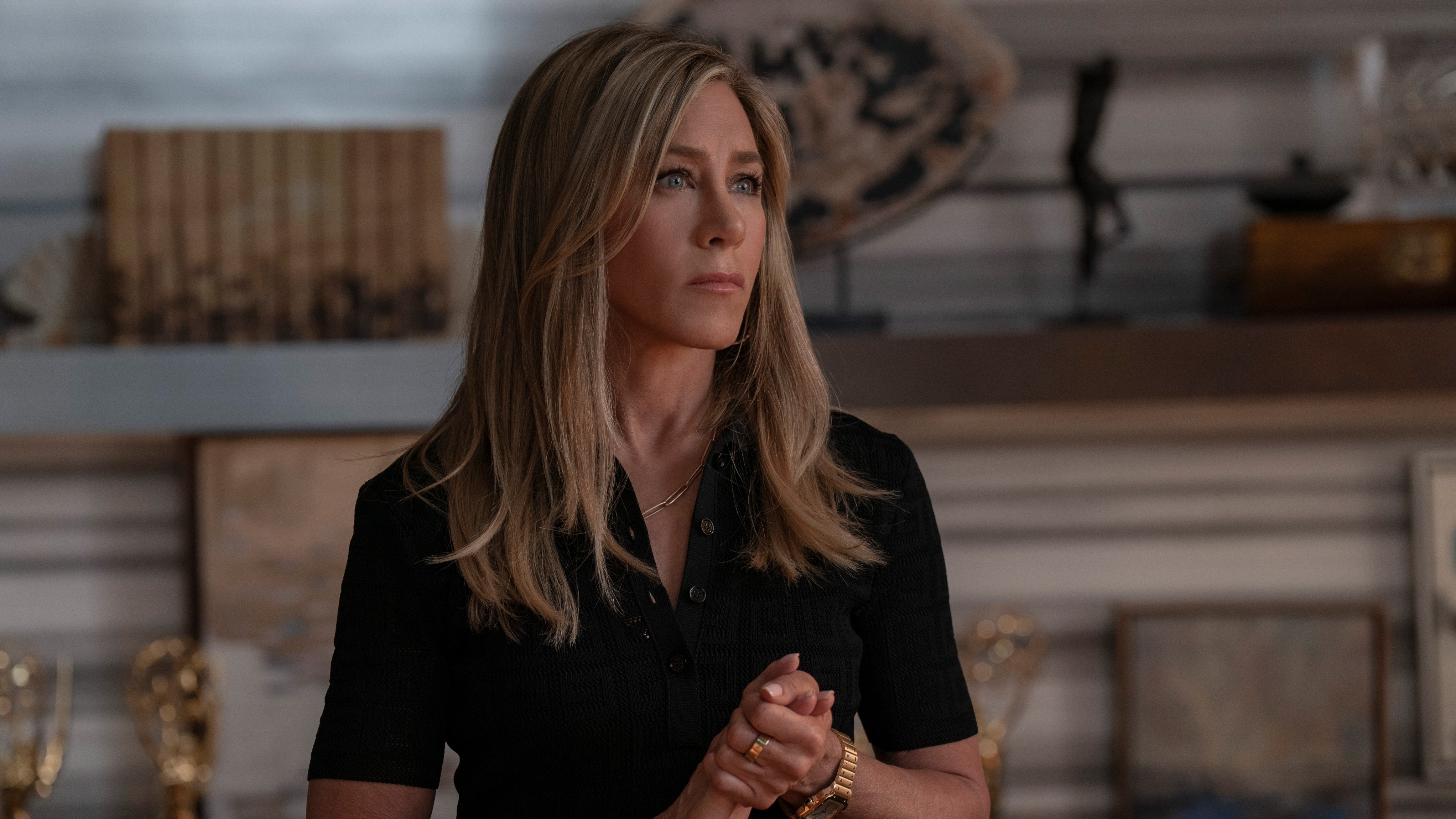 Jennifer Aniston clutching her hands in front of her