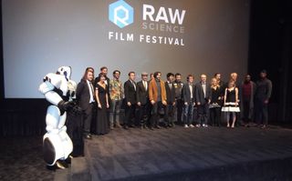 Competition contestants and presenters gather on stage with Maxx the robot at the conclusion of the Raw Science Film Festival.
