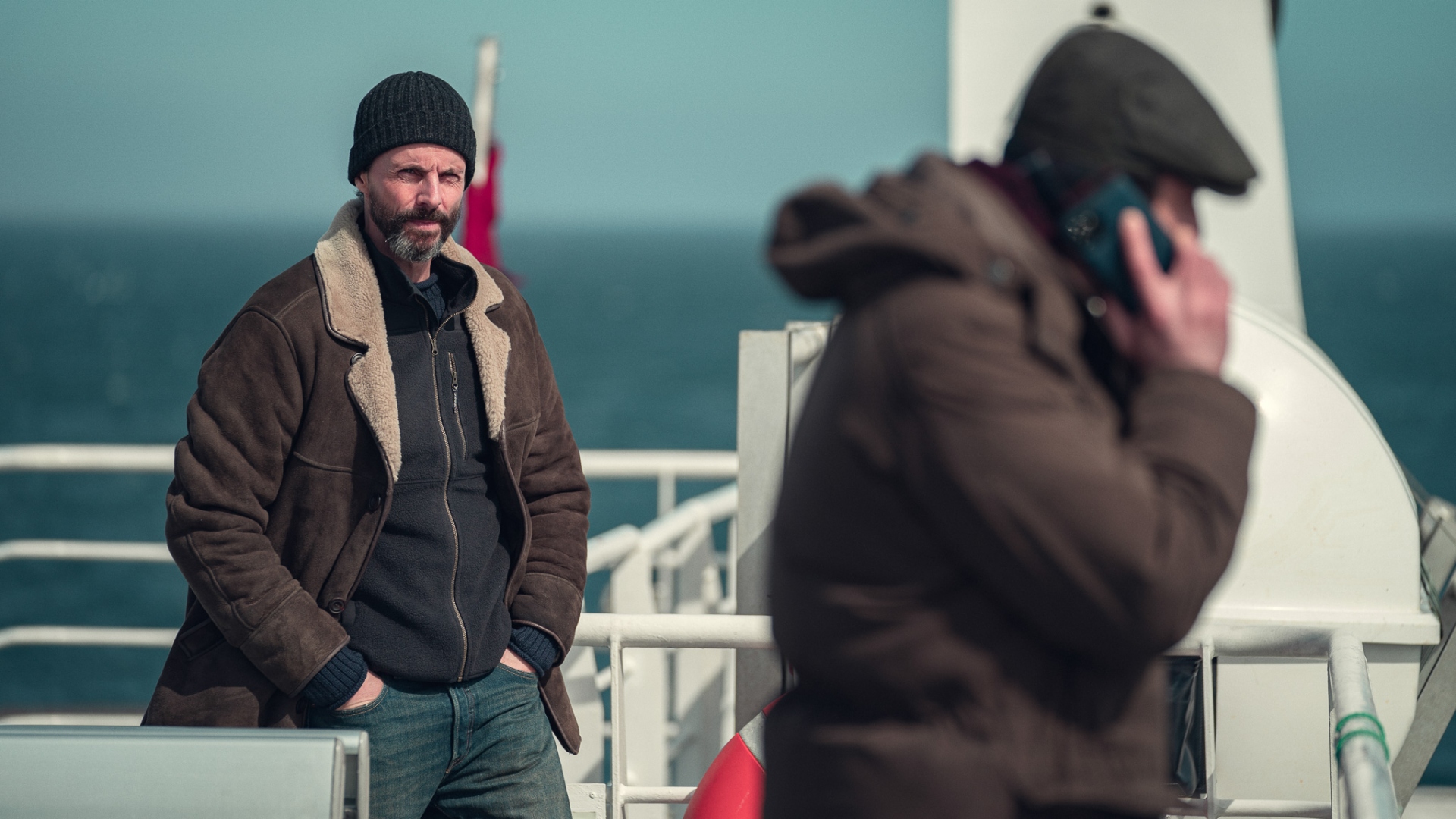 Carl stares at someone on a ferry in Department Q