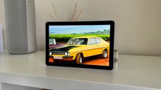 Amazon Fire HD 10 (2023) tablet on white shelf with yellow car on screen