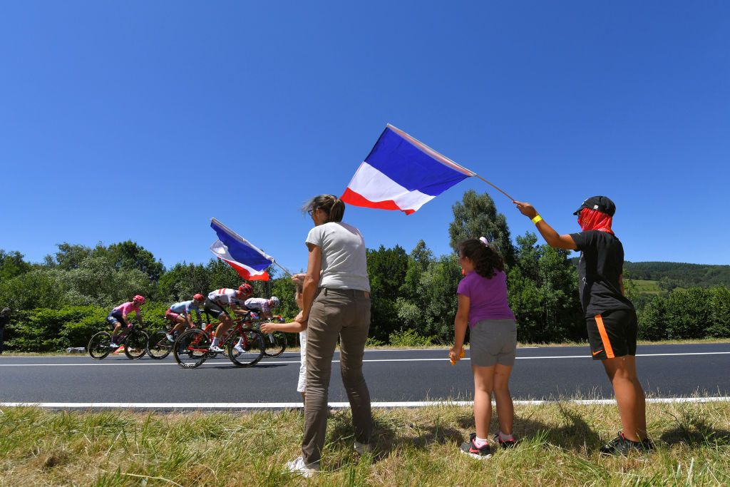 Fans with the French flag watch the breakaway go by