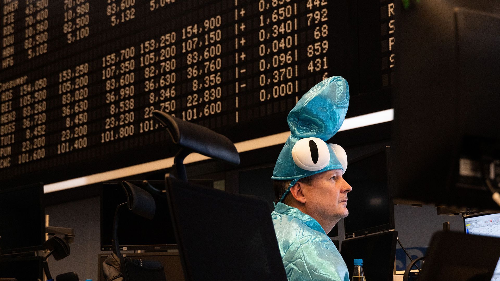 
                                A broker in costume works on the trading floor at the Frankfurt Stock Exchange during the carnival in Frankfurt, Germany
                            