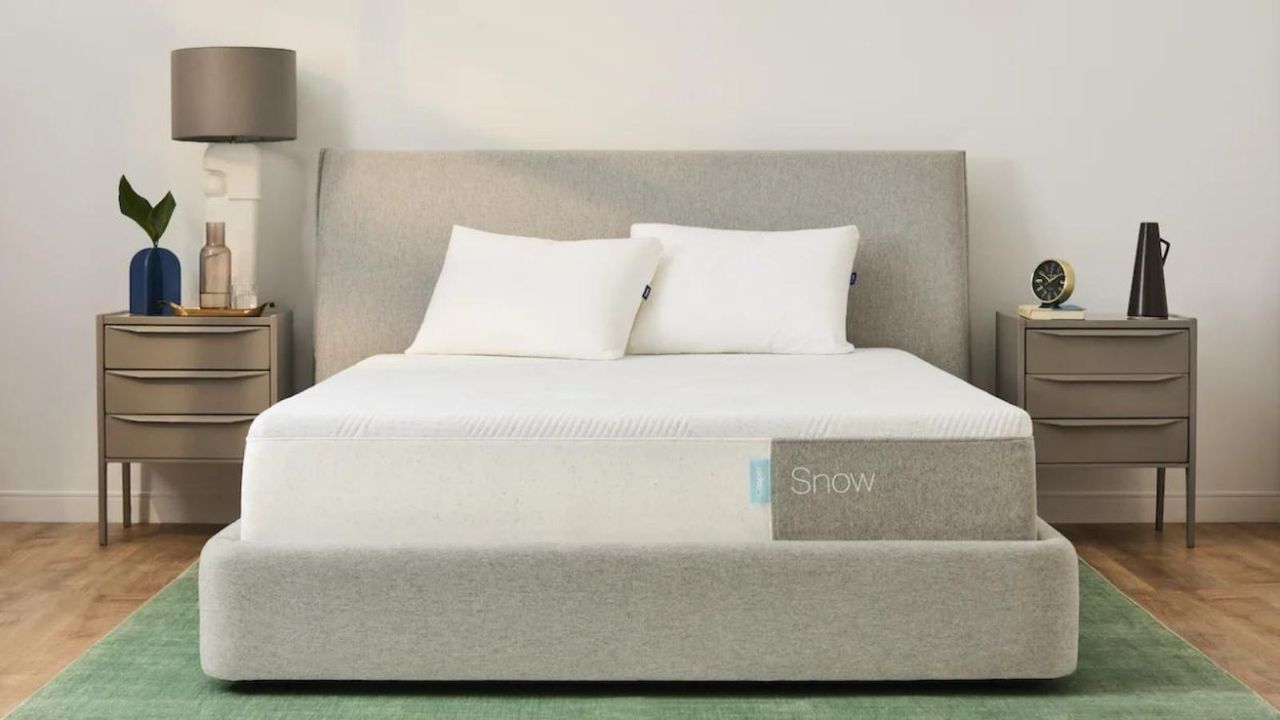 The Casper Snow Mattress on a bed with a nightstand either side against a white wall.