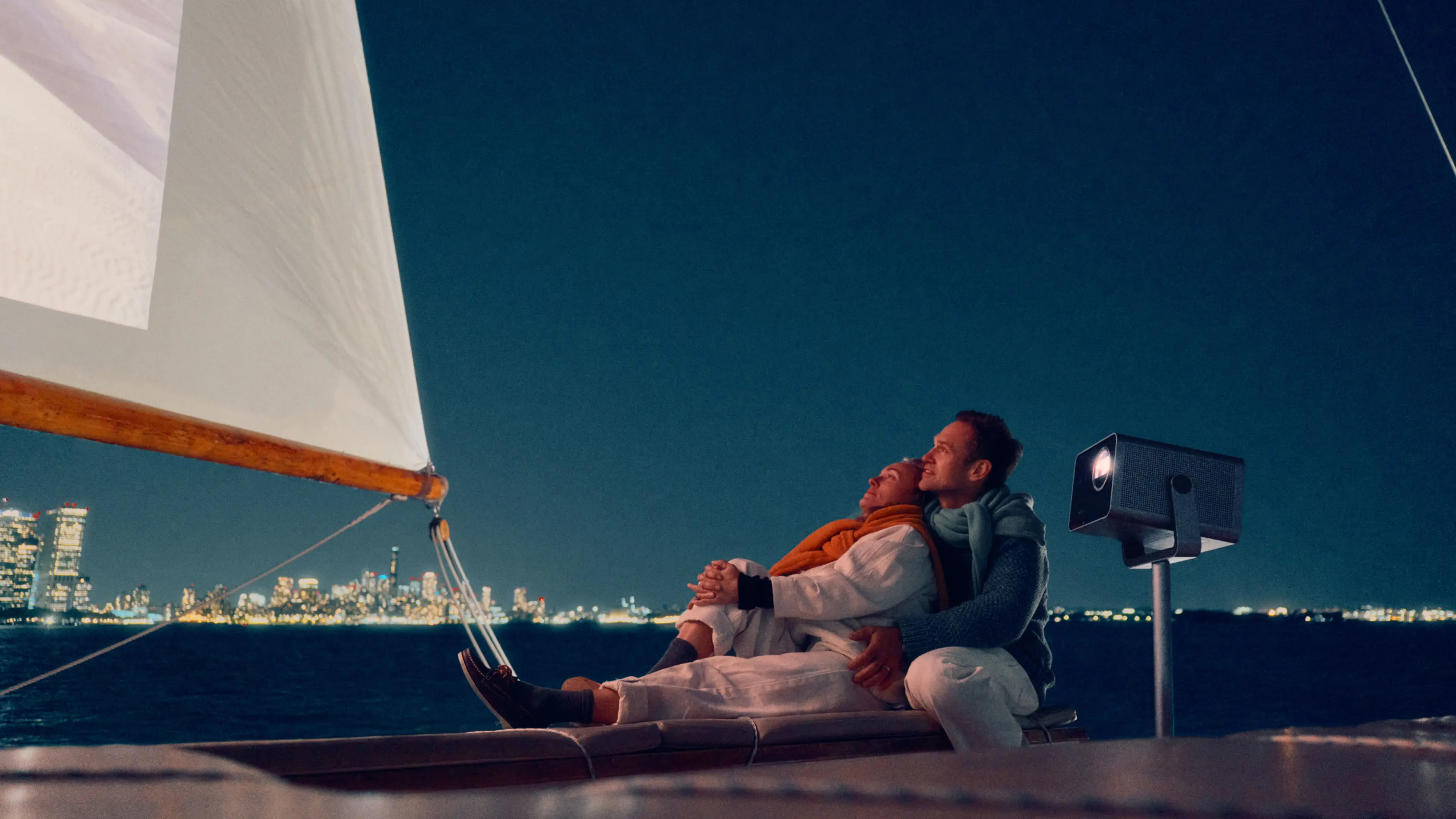 Two people watching the Leica CinePlay 1 projected on a sail.