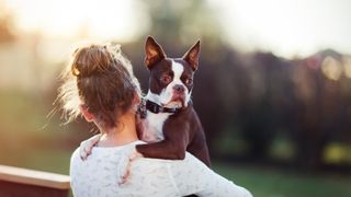 Woman holds nervous looking dog 
