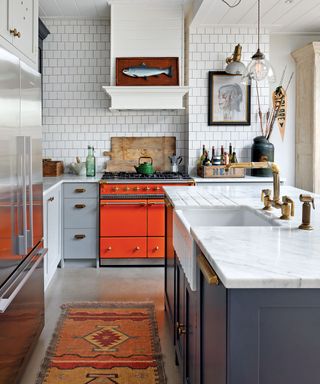 White kitchen with metro tiles and orange range cooker