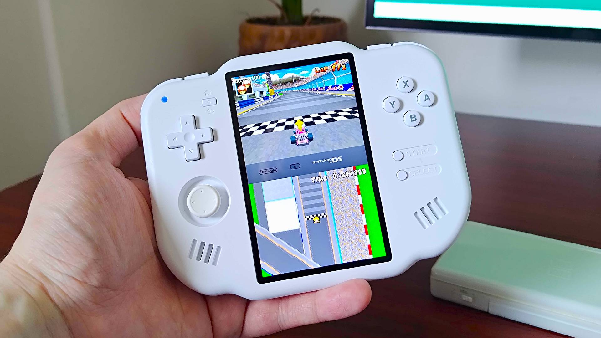 Hand holding MagicX Zero 40 running Mario Kart DS.