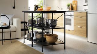 Black and wooden freestanding kitchen island used as a pan storage idea