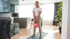 Woman holding kettlebell in domestic setting