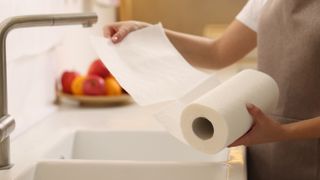Rolling out a kitchen towel by a sink