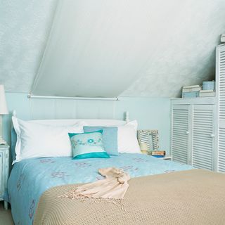 blue attic bedroom with cupboard and bed
