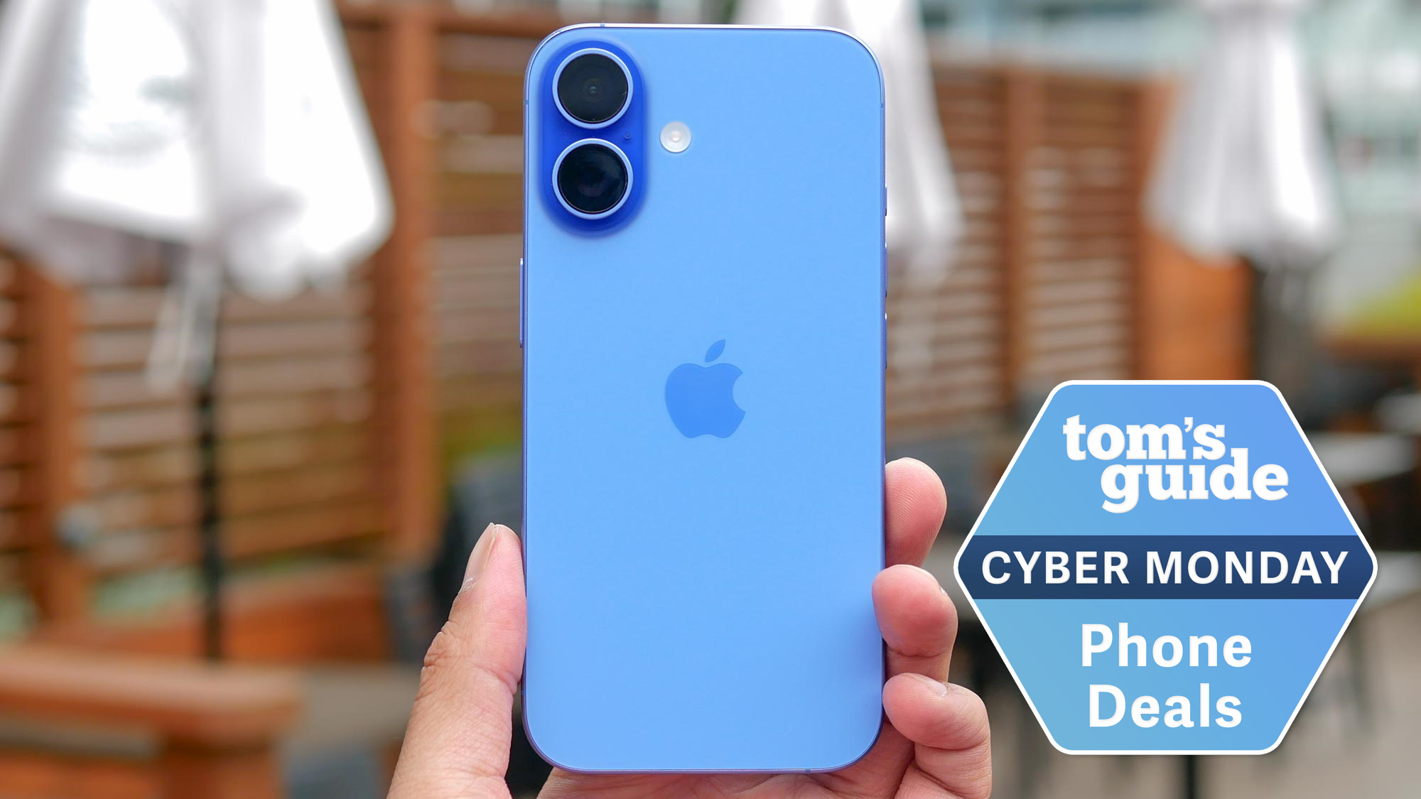 iPhone 16 held in the hand with Cyber Monday badge.