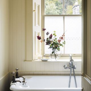 bathroom with cream colour wall bathtub and window