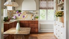 A country-style kitchen with dark wood bottom cabinets and rustic wooden kitchen table / Cathy Nordström Faye fabric credit Fanny Radvik Inuti Design