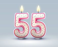 Two lit candles in the shape of the number 5, representing a 55th birthday.