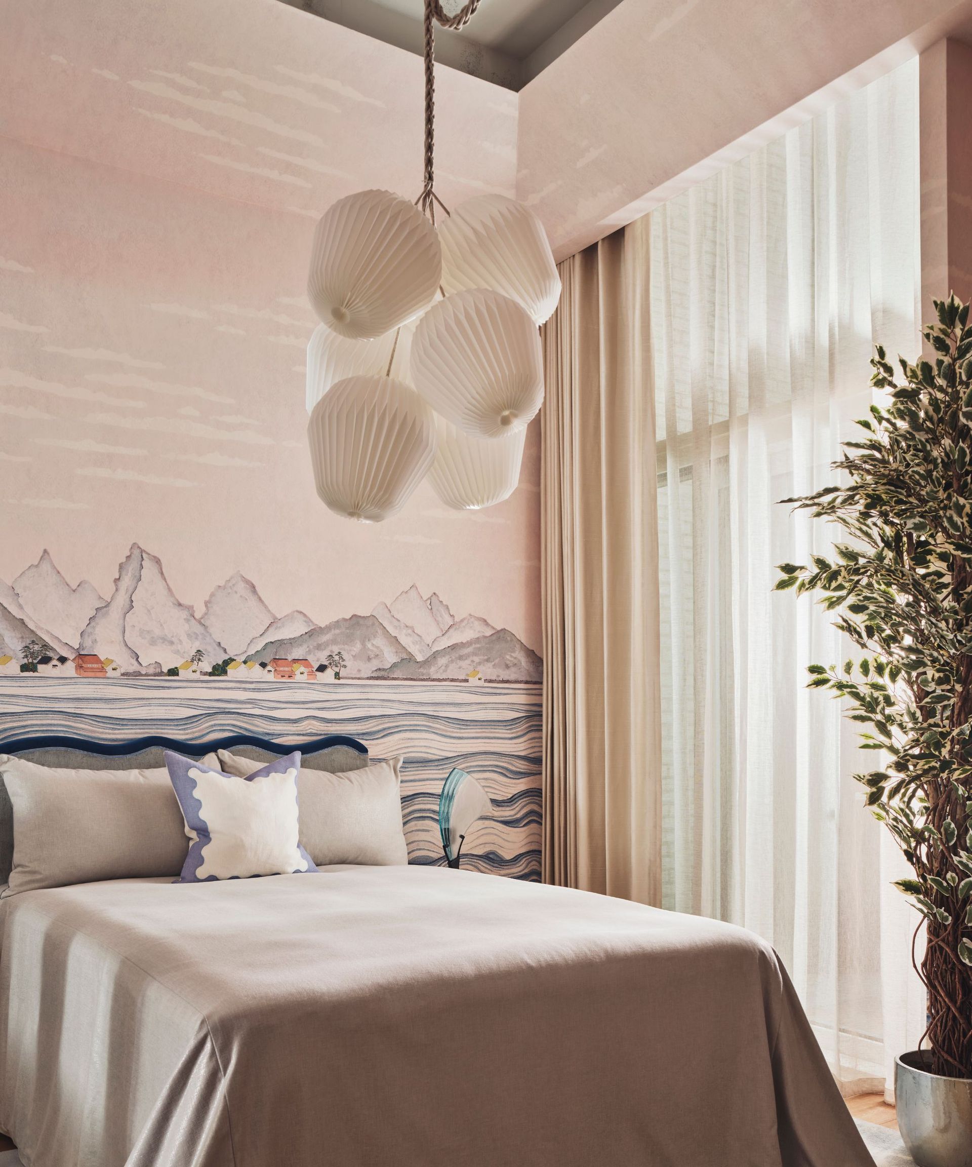 Pink bedroom mural with mountain design, bed, white lights