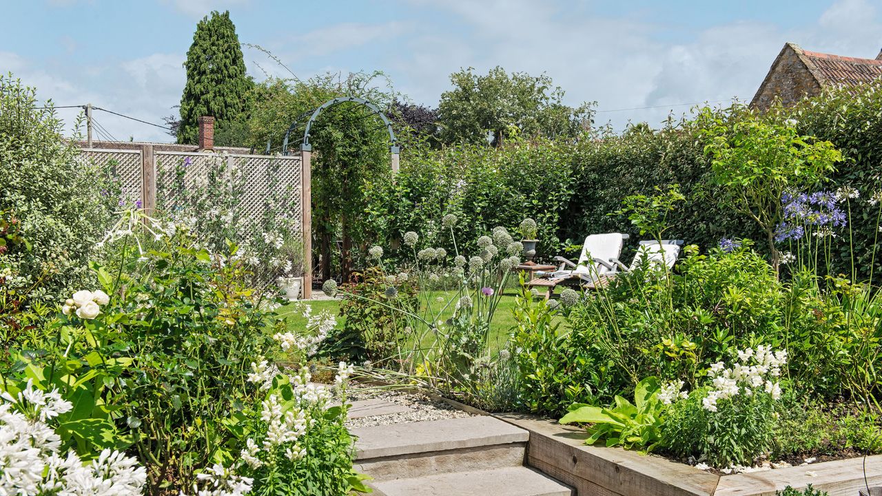 A terraced garden, transformed from a sloping garden, with patio, seating area and steps