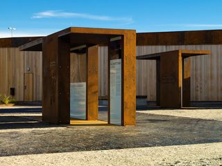 seven small CorTen steel-clad semi-open pavilions