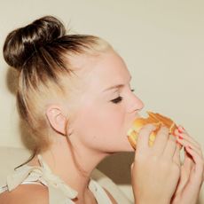 Psychology of Food Shaming: woman eating a burger