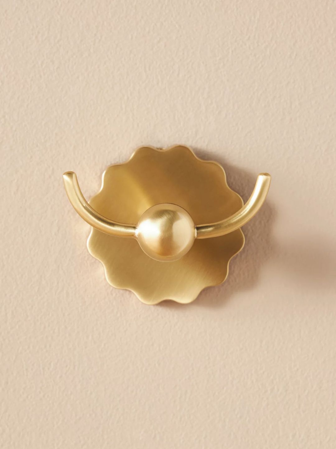 A gold bath hook from Anthropologie with a wavy edge