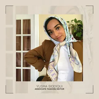 Yusra wears a patterned silk scarf, brown blazer, and white t-shirt.