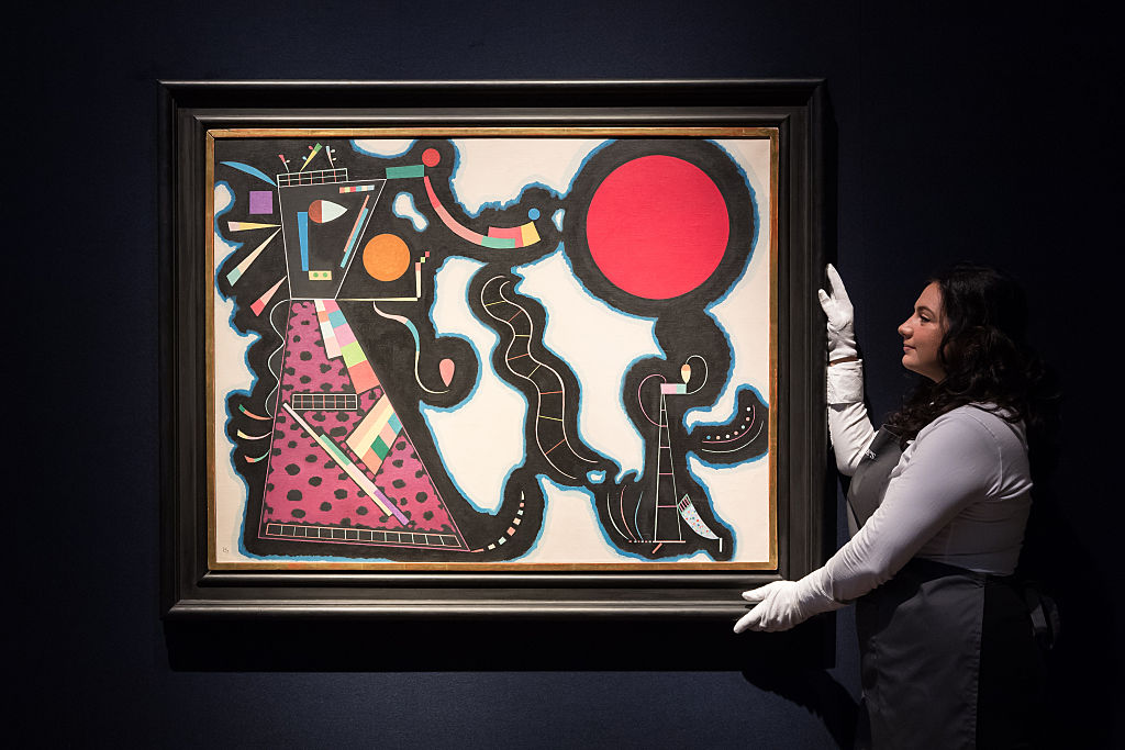 An art handler holds 'Le rond rouge' by Wassily Kandinsky