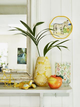 styling shelves: mantle piece styled with yellow toned accessories, a great example of how to design a shelf