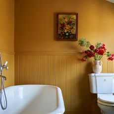 bathroom with yellow walls and roll top bath